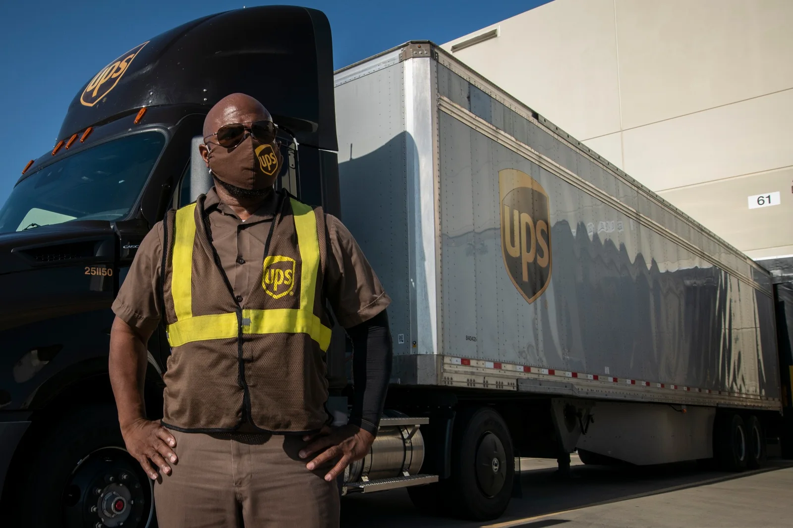 UPS feeder driver standing beside a brown tractor in Arlington, Texas, in a 2020 USDA photograph